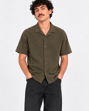 Camisa de polo khaki de manga corta con botones y bordado en el pecho, modelo masculino.