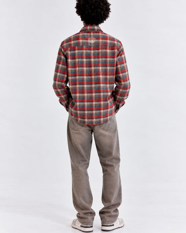 Camisa de franela de cuadros en tonos rojo y verde, vista trasera, con logo visible en la parte superior.