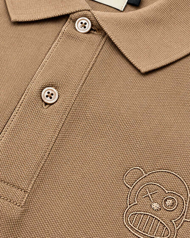 Polo de hombre color caramelo con bordado de un mono y botones claros, etiqueta visible de Loco Monky.