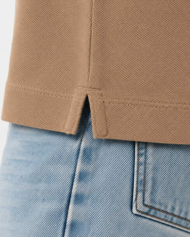 Polo de hombre en color caramelo con detalle de costura en la parte inferior y abertura lateral