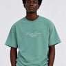 Camiseta verde con bordado en blanco que dice 'Bendita Locura' y 'Loco Monky' en el pecho.