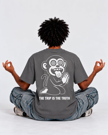 Camiseta gris oscuro con diseño de mono en la espalda, texto "THE TRIP IS THE TRUTH" debajo del diseño.