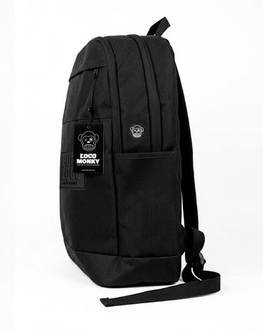 Mochila unisex color negro con etiqueta visible de Loco Monky y diseño sencillo, vista lateral.