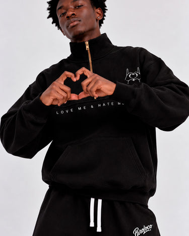 Sudadera oversize negra con cremallera, texto 'LOVE ME & HATE ME' y diseño de corazón en el pecho.