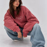 Sudadera oversize color vino con bordado "Bendita Locura" en el pecho, modelo con jeans claros.