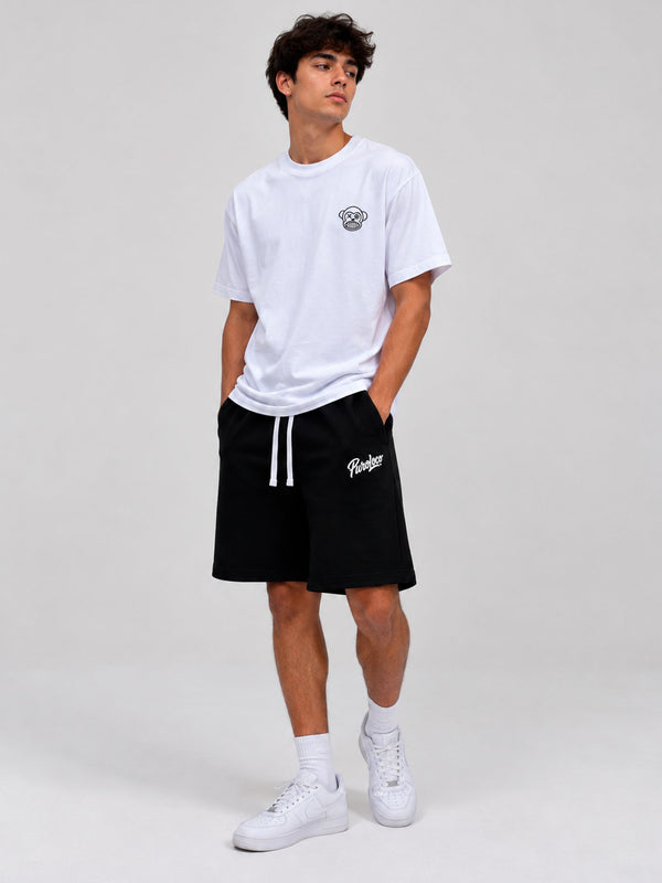 Pantalones cortos negros con cordón blanco y logo en la pierna, combinados con camiseta blanca.