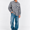 Camisa de franela de cuadros en tonos azul y gris, con dos bolsillos frontales, combinada con jeans claros.