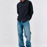 Camisa de franela navy con dos bolsillos frontales, combinada con jeans claros y zapatillas blancas.