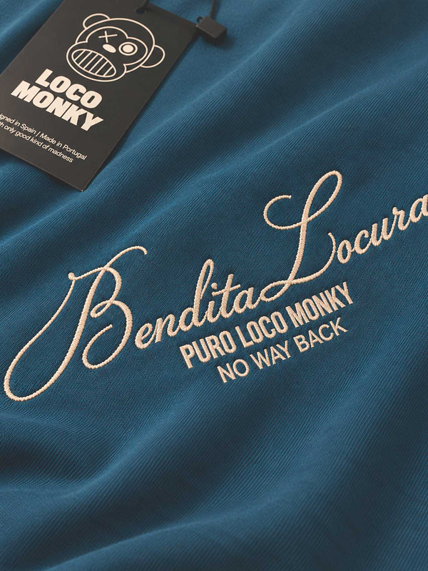 Camiseta azul con bordado en color claro que dice 'Bendita Locura' y etiqueta de Loco Monky