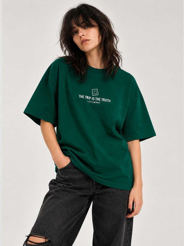 Camiseta boxy unisex de color verde oscuro con texto "THE TRIP IS THE TRUTH" y logo de LOCO MONKY