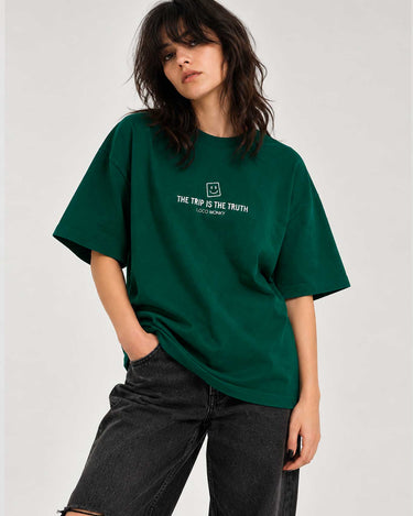 Camiseta boxy unisex de color verde oscuro con texto "THE TRIP IS THE TRUTH" y logo de LOCO MONKY