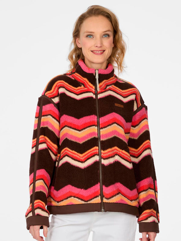 Forro polar de mujer con diseño de zigzag en tonos marrón, rosa y naranja, cierre frontal y cuello alto.