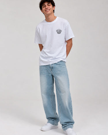 Pantalón vaquero azul claro con corte amplio, combinado con camiseta blanca y zapatillas blancas.