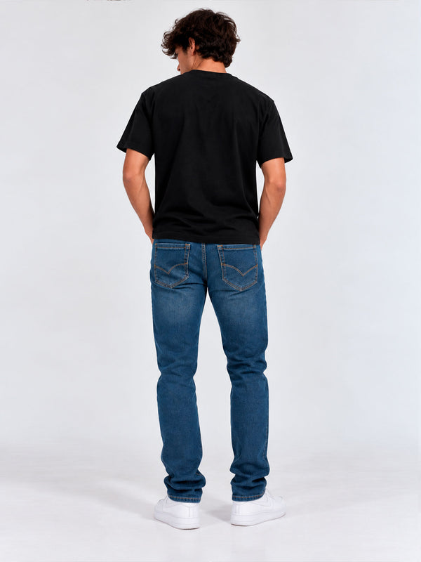 Pantalón vaquero azul para hombre, ajuste regular, con costuras visibles y detalles en los bolsillos traseros.