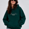 Sudadera unisex verde oscuro con capucha, bordado 'Bendita Locura' en el pecho y bolsillo frontal.