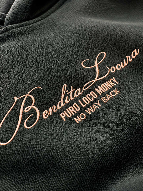 Sudadera unisex color verde oscuro con bordado en rosa que dice 'Bendita Locura Puro Loco Monky No Way Back