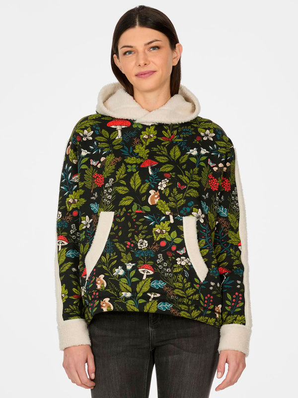 Sudadera de mujer con estampado floral en tonos verdes y negros, interior borreguito, capucha y bolsillos.