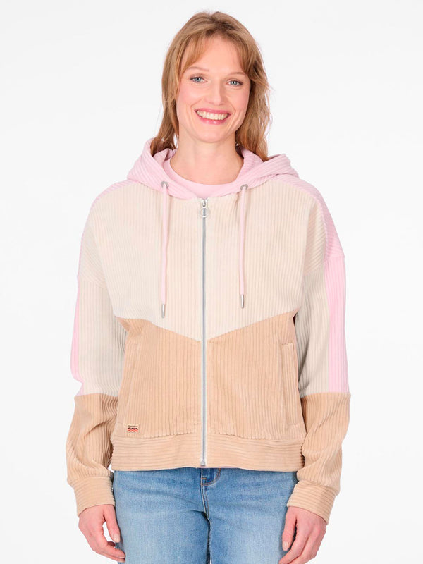 Chaqueta de pana de mujer en tonos beige, rosa y crema, con capucha y cierre frontal.