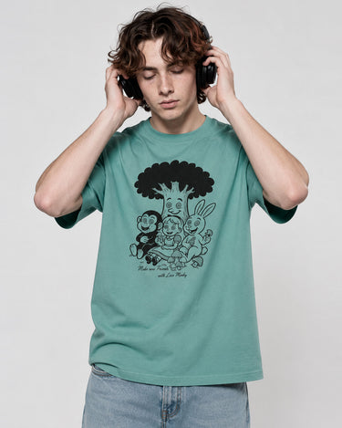 Camiseta verde con estampado en negro de personajes caricaturescos, modelo usando auriculares.