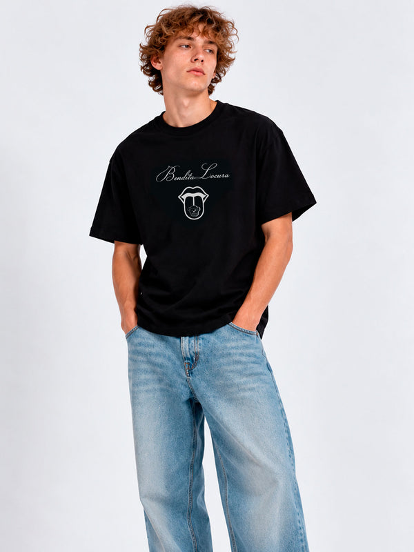 Camiseta negra con diseño gráfico en el pecho, modelo masculino usando jeans claros.