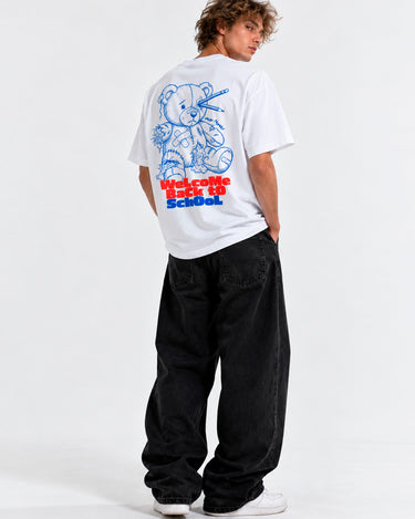 Camiseta blanca unisex con diseño azul de un oso y texto en rojo en la parte posterior, pantalones negros.