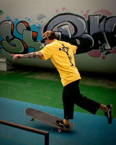 Skater usando la camiseta Pray For Monky de Loco Monky yellow, diseño ético y sostenible, perfecta para el estilo urbano.