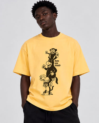 Camiseta amarilla con estampado negro de animales apilados y texto 'Make new friends