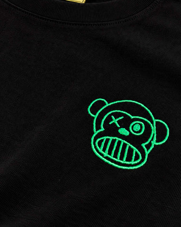 Camiseta negra con bordado verde de un mono con cara de calavera en el pecho, etiqueta visible de Loco Monky.