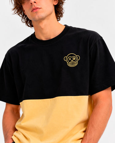 Camiseta de hombre en negro y amarillo suave, con un diseño de mono en el pecho.