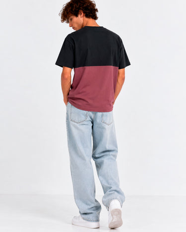 Camiseta unisex en negro y morado, vista trasera, combinada con jeans claros y zapatillas blancas.