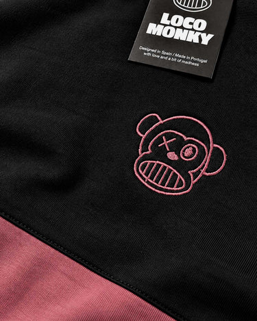 Camiseta negra con detalle en rosa y bordado de un mono con cara sonriente, etiqueta de Loco Monky visible.
