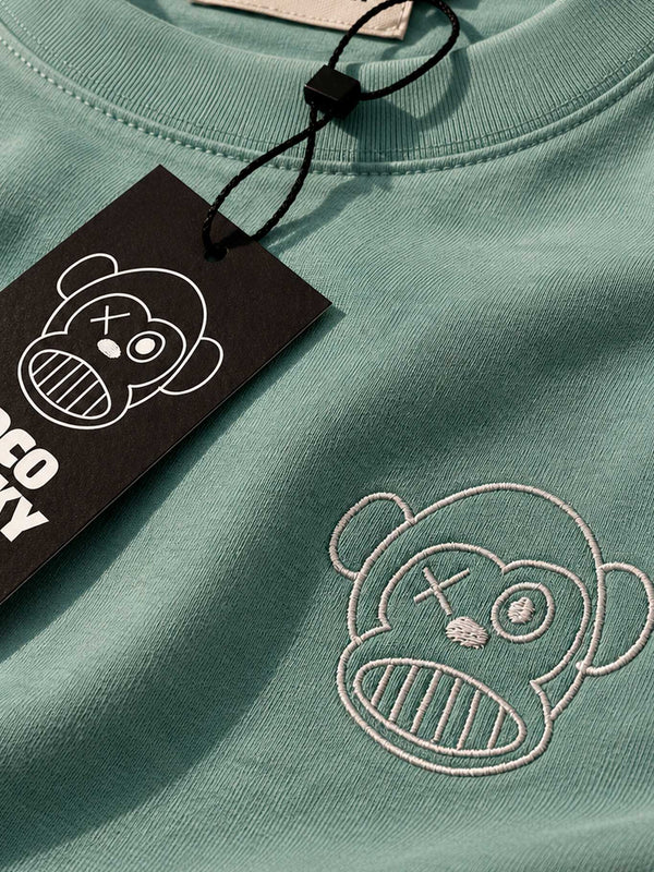 Camiseta verde con bordado de un mono en el pecho y etiqueta negra con el logo de Loco Monky.