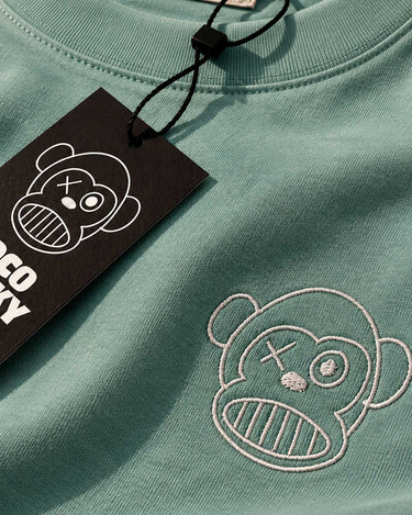 Camiseta verde con bordado de un mono en el pecho y etiqueta negra con el logo de Loco Monky.