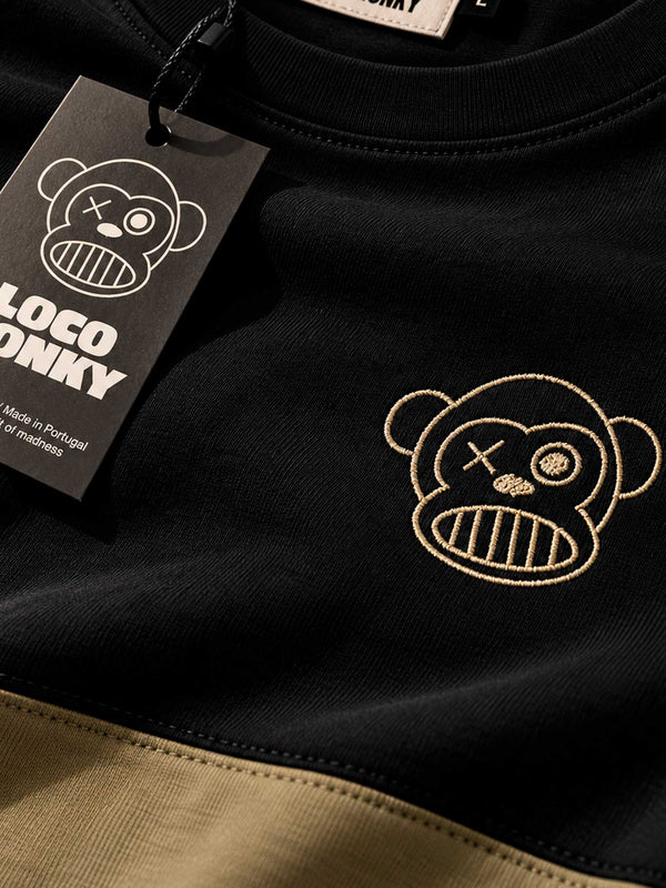 Camiseta negra con detalle en oliva, logo de Loco Monky y etiqueta colgante.