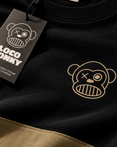 Camiseta negra con detalle en oliva, logo de Loco Monky y etiqueta colgante.