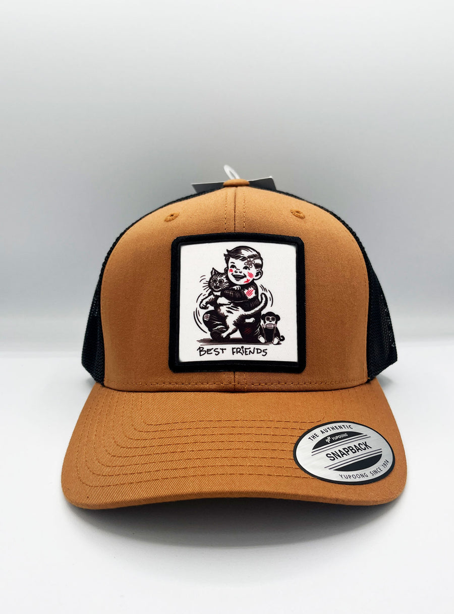 Gorra trucker Best Friends de Loco Monky en caramelo y negro, perfecta para estilo y comodidad.