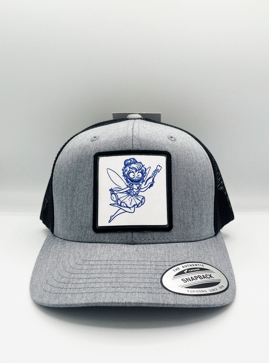 Gorra trucker Tooth Fairy de Loco Monky, con parche del hada de los dientes y estilo clásico en color negro y gris.