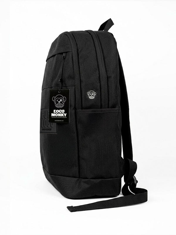 Mochila unisex color negro con etiqueta visible de Loco Monky y diseño sencillo, vista lateral.