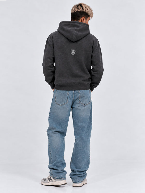 Sudadera unisex gris oscuro con capucha, bordado en la parte posterior, combinada con jeans claros.