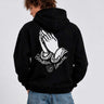 Sudadera negra con capucha, diseño de manos en oración y texto 'Bendita Locura' en la espalda.