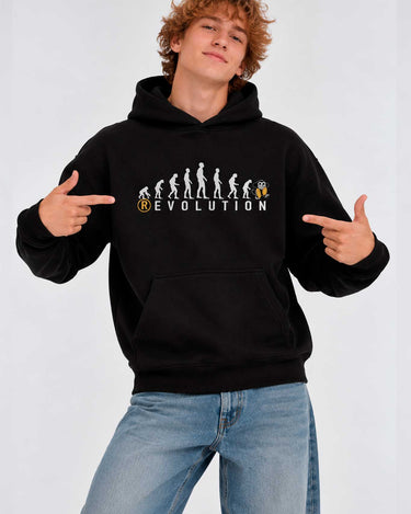 Sudadera negra con capucha, diseño gráfico de evolución y texto 'REVOLUTION', modelo masculino señalando.