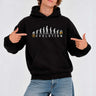 Sudadera negra con capucha, diseño gráfico de evolución y texto 'REVOLUTION', modelo masculino señalando.