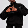 Sudadera oversize negra con cremallera, texto 'LOVE ME & HATE ME' y diseño de corazón en el pecho.