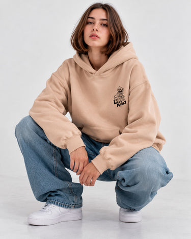Sudadera unisex color arena con capucha, logo de Loco Monky en el pecho, combinada con jeans holgados.