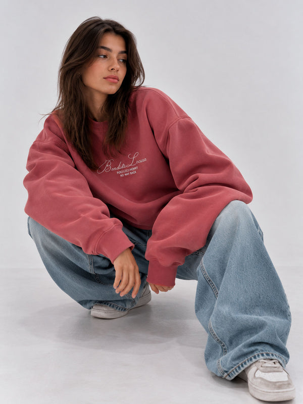 Sudadera oversize color vino con bordado "Bendita Locura" en el pecho, modelo con jeans claros.