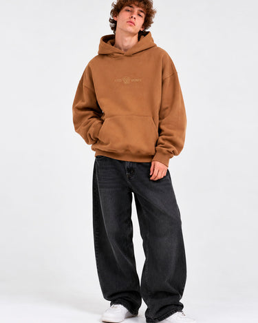 Sudadera oversize color marrón con capucha, logo de Loco Monky en el pecho, pantalones anchos y zapatillas blancas.