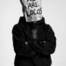 Sudadera negra con capucha, logo 'PURO LOCO' en el pecho, persona con bolsa de papel en la cabeza.