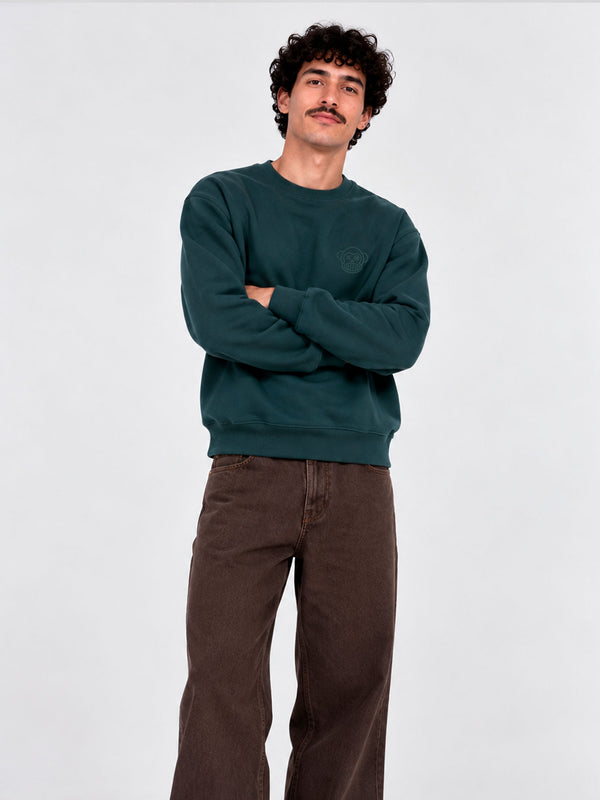 Sudadera de hombre color verde oscuro con cuello redondo, modelo de Loco Monky, con un hombre posando.
