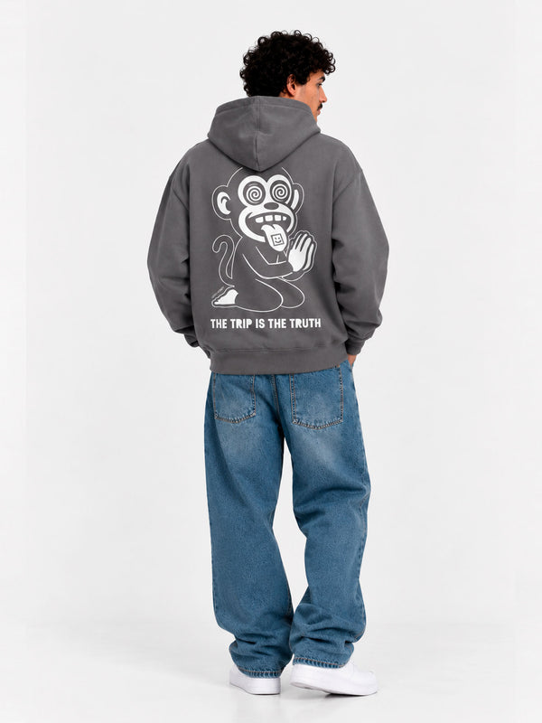 Sudadera unisex gris oscuro con diseño de mono en la espalda y texto 'THE TRIP IS THE TRUTH'.