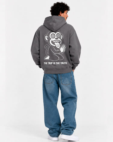 Sudadera unisex gris oscuro con diseño de mono en la espalda y texto 'THE TRIP IS THE TRUTH'.